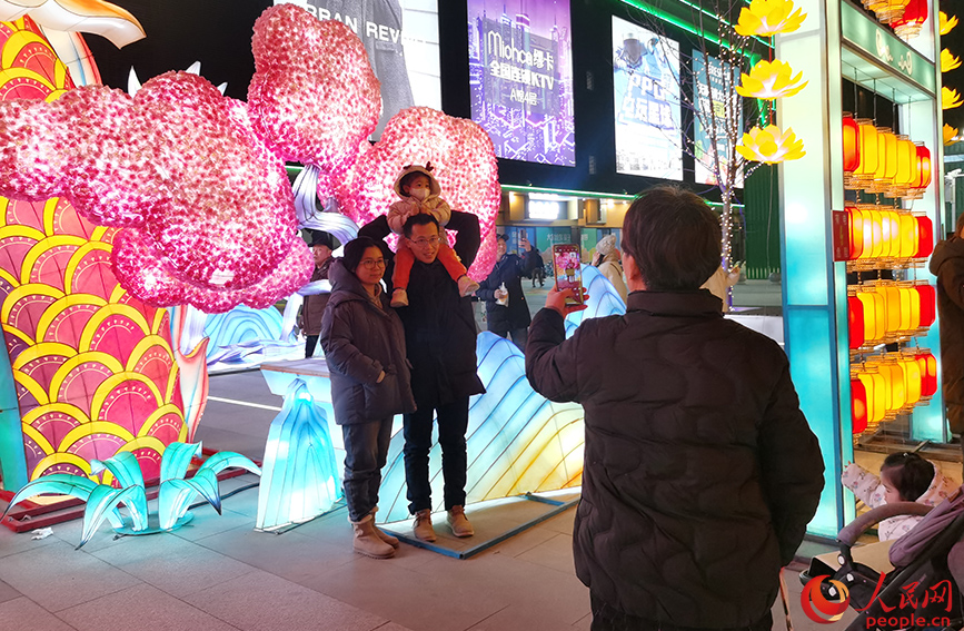 2023年12月31日，天津市民在西青大悦汇龙形灯饰前拍照留念。人民网记者 陶建摄