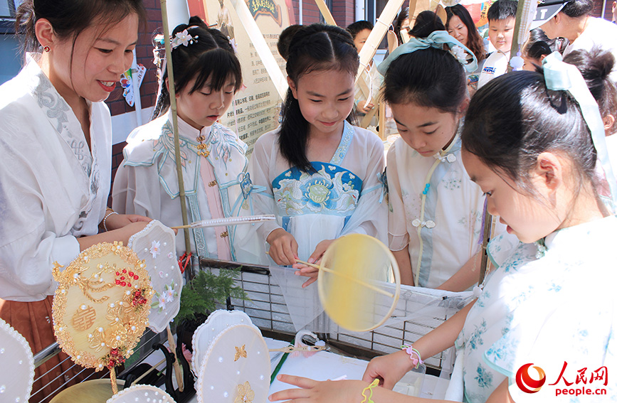 学生体验蚕丝扇制作。人民网记者 张静淇摄