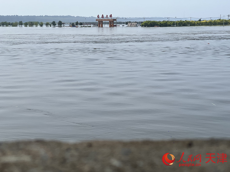 “生态六埠”景区门牌高5米，9日上午11：30，目测水位已达到门牌腰部以上。人民网记者 孙翼飞摄