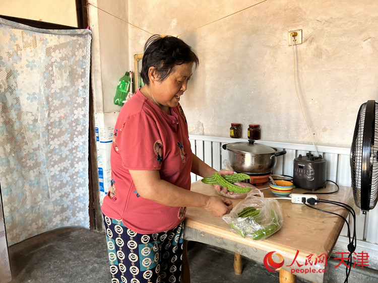 寇大爷的老伴准备中午包饺子，顺便做一个凉拌苦瓜。人民网记者 孙翼飞摄