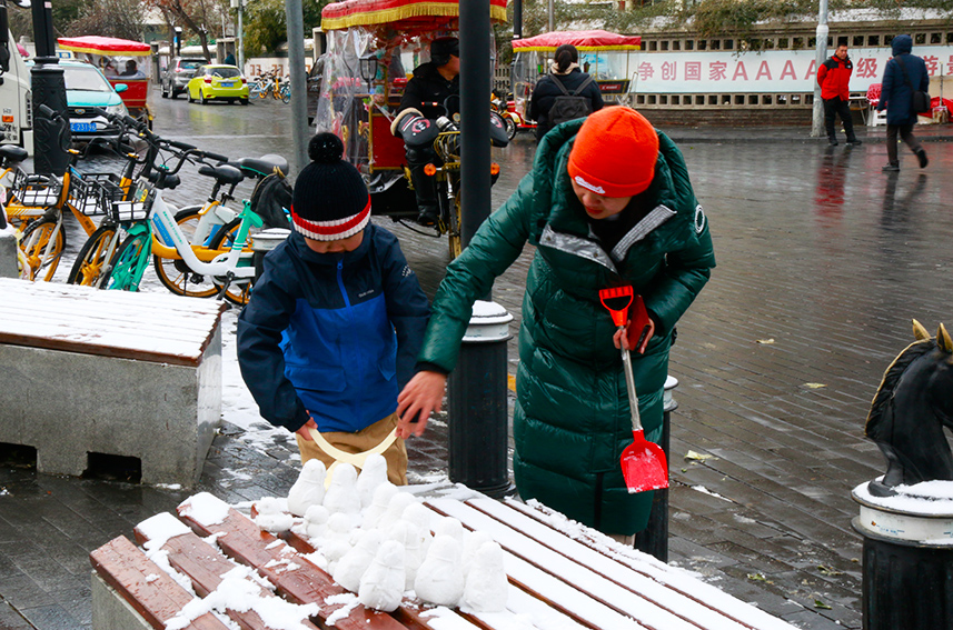 市民和孩子在玩雪。实习生吕文雅摄