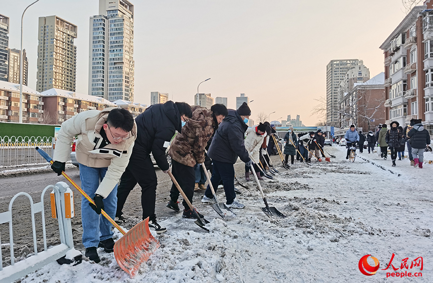 天津市河西区马场街道办事处街道机关干部在吴家窑大街清扫积雪。人民网记者 陶建摄