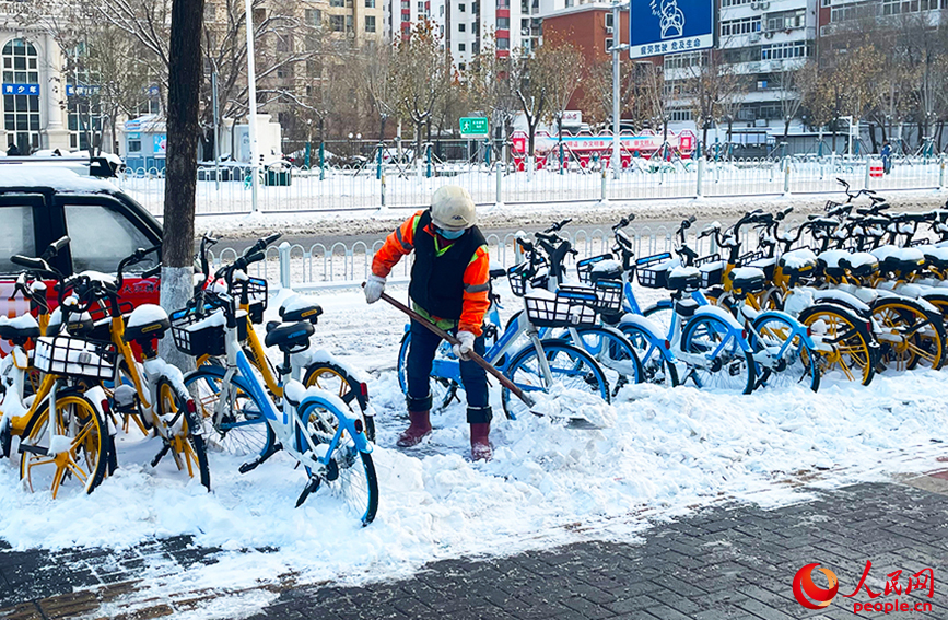 勤俭道地铁站附近，环卫工人奋力清扫积雪。人民网记者 唐心怡摄