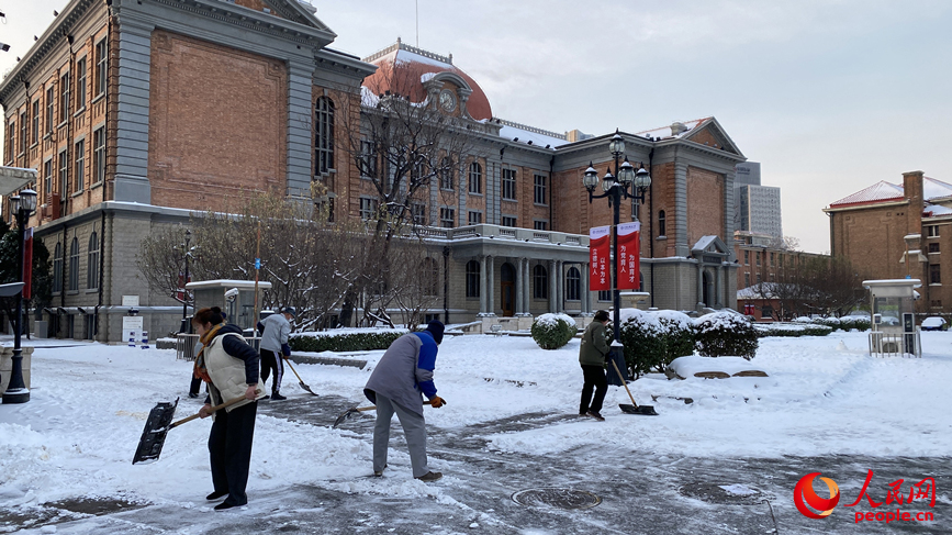 天津外国语大学内，工作人员正在清理校内积雪。人民网记者 张桂贵摄